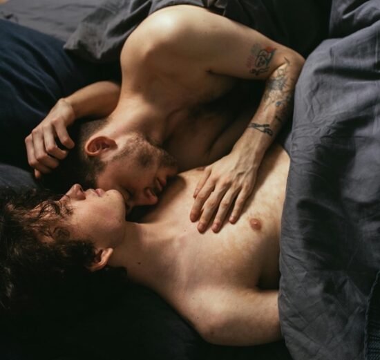 двое мужчин лежат в постели